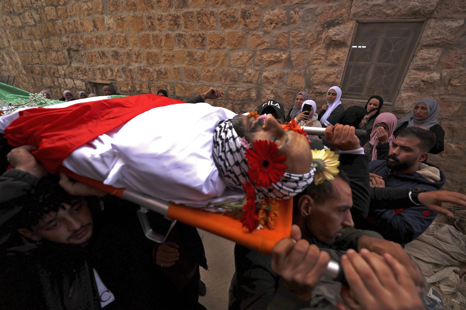 Enlutados carregam o corpo de homem palestino durante confrontos com as forças israelenses na vila de Beit Duquu, a noroeste de Jerusalém. — Foto: ABBAS MOMANI / AFP