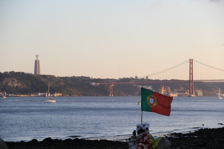 Bandeira de Portugal fincada na margem do Rio Tejo, em Lisboa