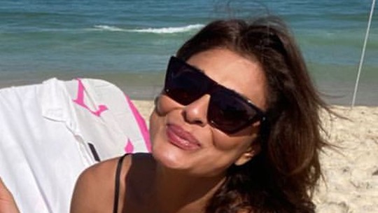 Juliana Paes come milho em dia de praia com o marido, Dudu Baptista