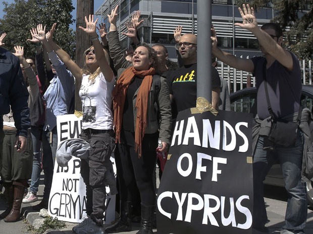 Manifestantes protestam enquanto o comboio do presidente do país, Nicos Anastasiades, chega ao Parlamento nesta segunda-feira (18) em Nicosia, a capital do país (Foto: Yorgos Karahalis/Reuters)
