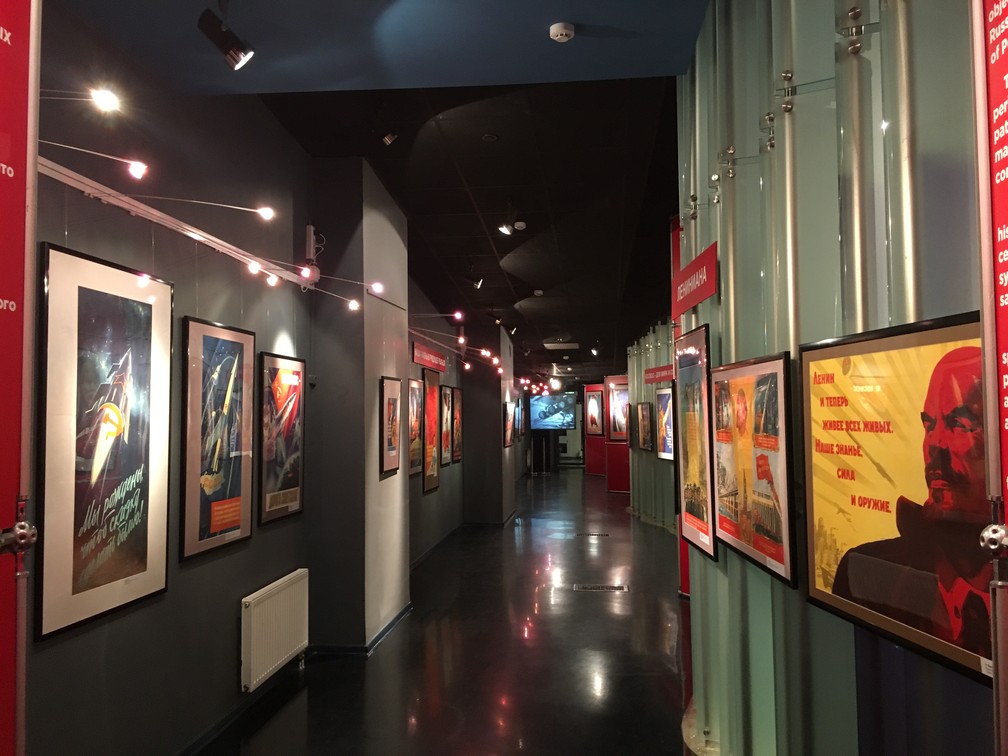 Corredor no museu expõe cartazes soviéticos que exaltam os feitos soviéticos na corrida espacial.  (Foto: G1/ Adriane Schultz)