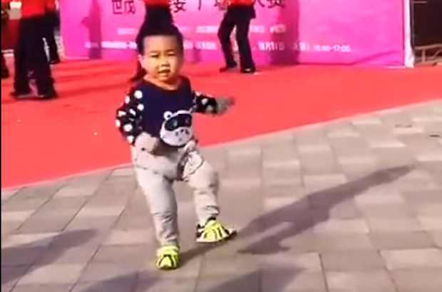 Menino chinês dançando ao lado do palco (Foto: Reprodução Youtube)