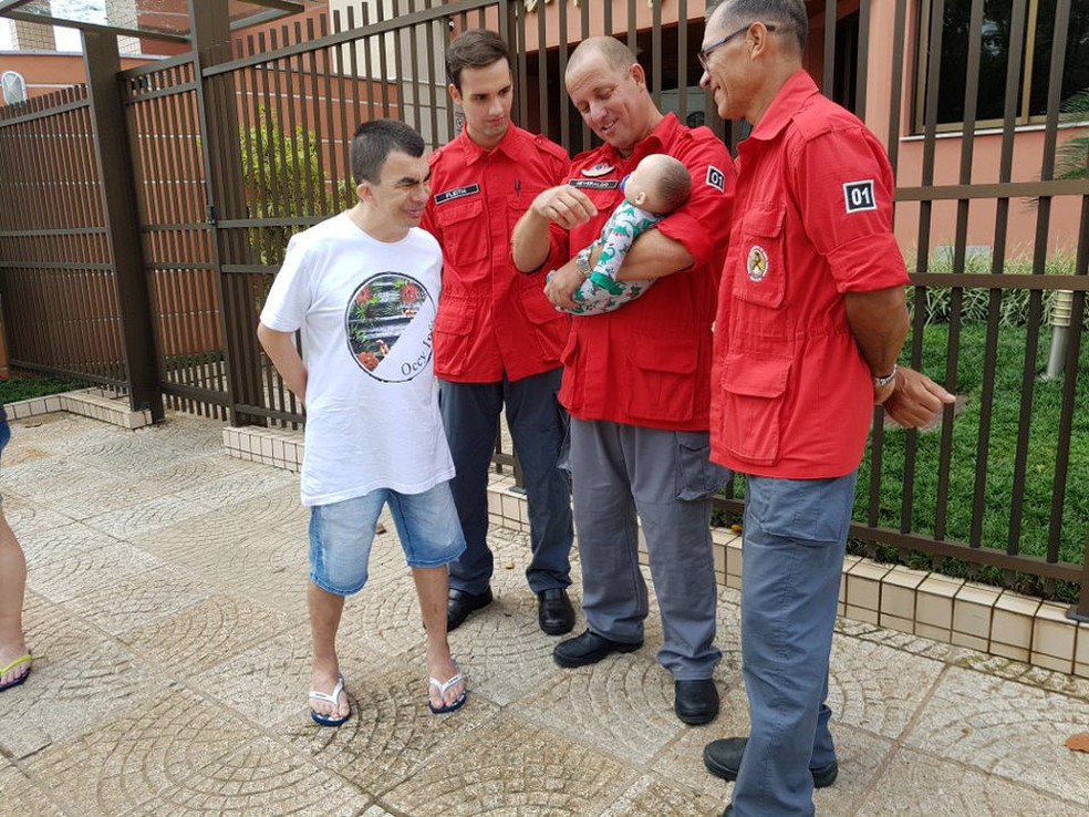 Bombeiro Heveraldo Santos segura boneco Nico na presença de outros bombeiros voluntários e de Sérgio da Silva — Foto: CBVJ/Divulgação