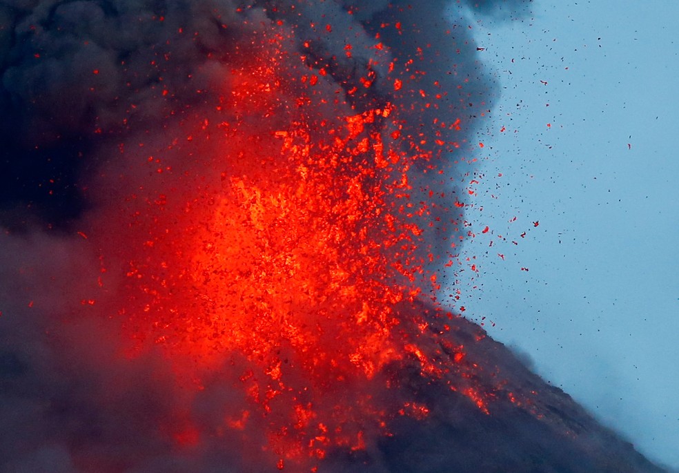 O vulcão Mayon expele lava durante uma erupção esporadica no início desta quinta (25) visto de Legazpi, nas Filipinas. Mais de 74 mil pessoas estão em dezenas de abrigos de emergência enquanto o vulcão continua soltando lava, cinzas, gases superaquecidos e pedras (Foto: Bullit Marquez/AP)