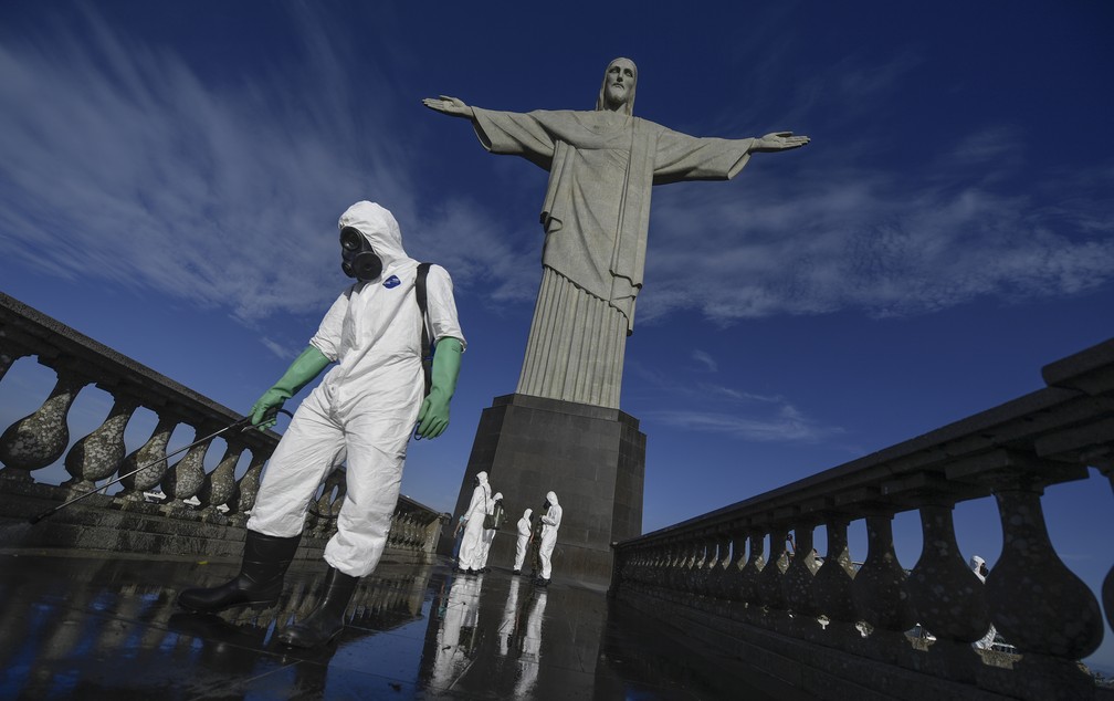 Membro das Forças Armadas desinfecta local onde fica o Cristo Redentor, no Corcovado, no Rio de Janeiro, contra a Covid-19. — Foto: Mauro Pimentel/AFP