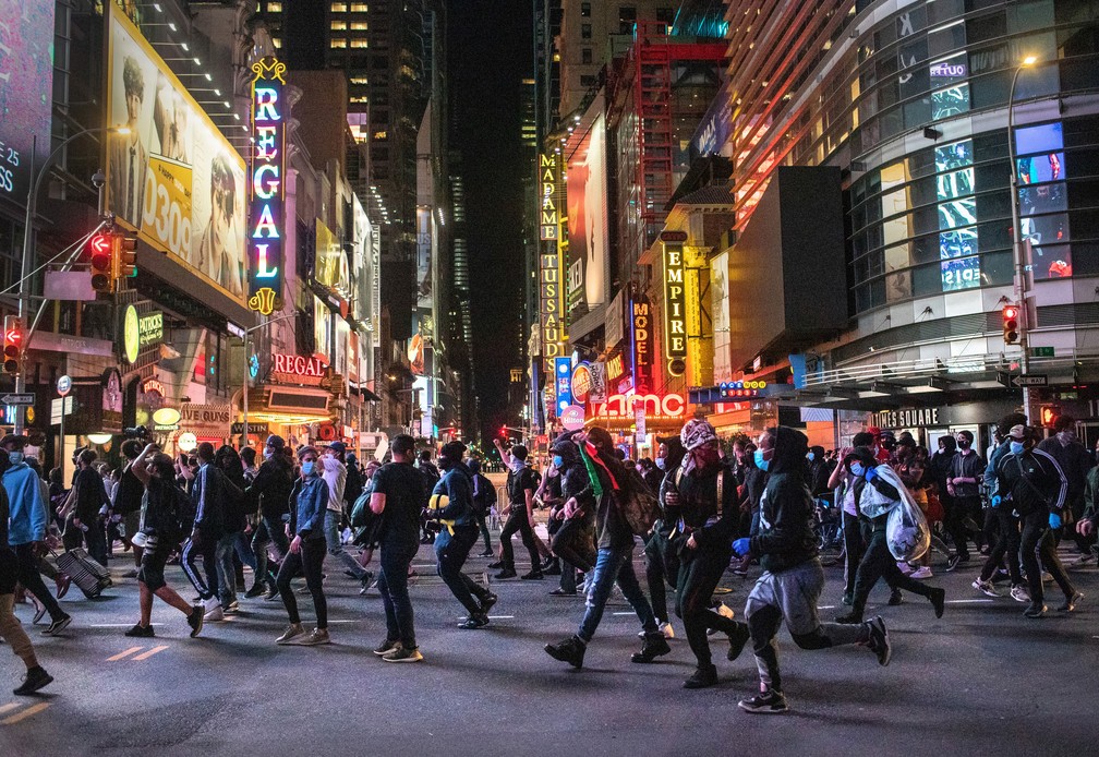 Manifestantes passam pela Times Square, em Nova York, após início do toque de recolher na noite de segunda-feira (1º) — Foto: John Moore / Getty Images via AFP