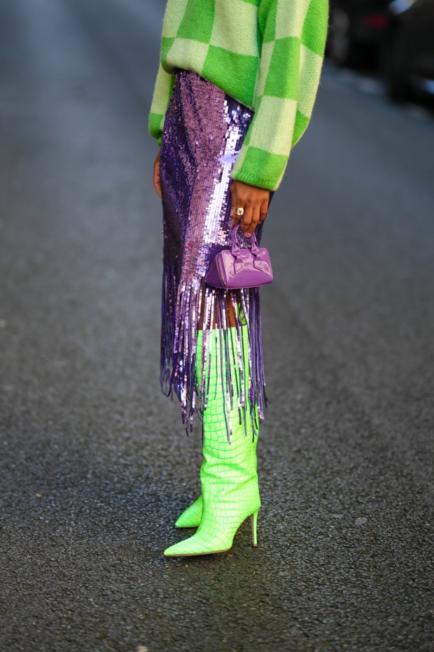 PARIS, FRANCE - JANUARY 14: Ellie Delphine wears a pale green and dark green checkered print pattern oversized high neck fluffy pullover, a purple shiny sequined fringed midi skirt, a purple shiny leather zipper small handbag, neon green shiny leather cro (Foto: Getty Images)