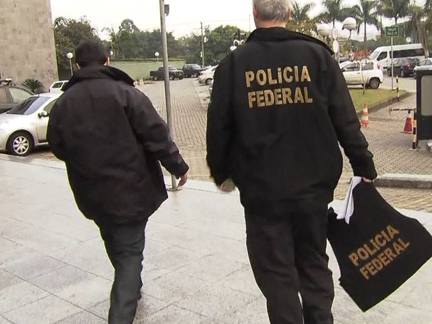 Policiais federais com malotes apreendidos na Operação Boca Livre (Foto: Reprodução/TV Globo)