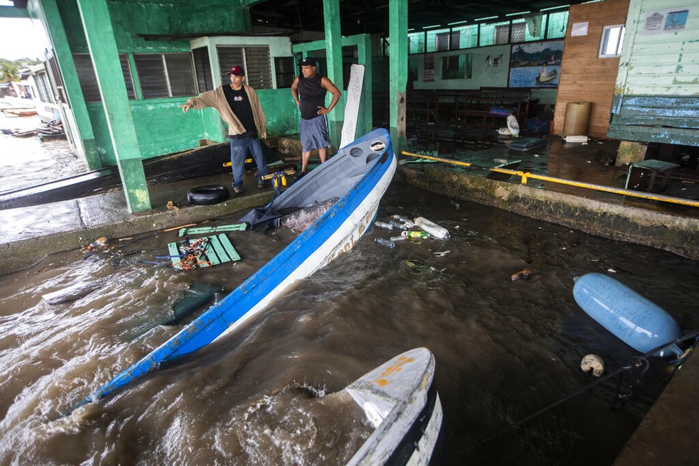 Pescadores em Bluefields, na Nicarágua, observam botes parcialmente submergidos após passagem de tempestade Julia, em 9 de outubro de 2022. — Foto: Inti Ocon/ AP