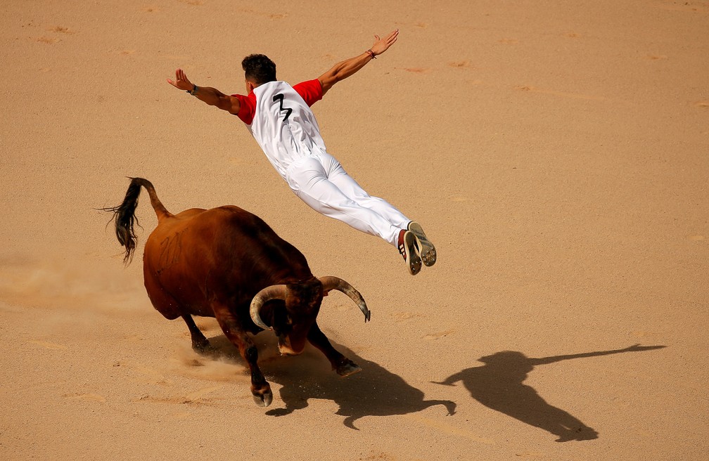 13 de julho - Um recortador salta de braços abertos sobre um touro durante disputa tradicional do Festival de São Firmino em arena de Pamplona, na Espanha — Foto: Jon Nazca/Reuters