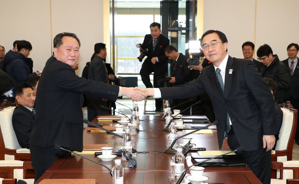 Chefe da delegação norte-coreana, Ri Son Gwon aperta a mão com o seu homólogo sul-coreano Cho Myoung-gyon durante a reunião na área desmilitarizada de Panmunjom, nesta terça-feira (9) (Foto: Yonhap via REUTERS)