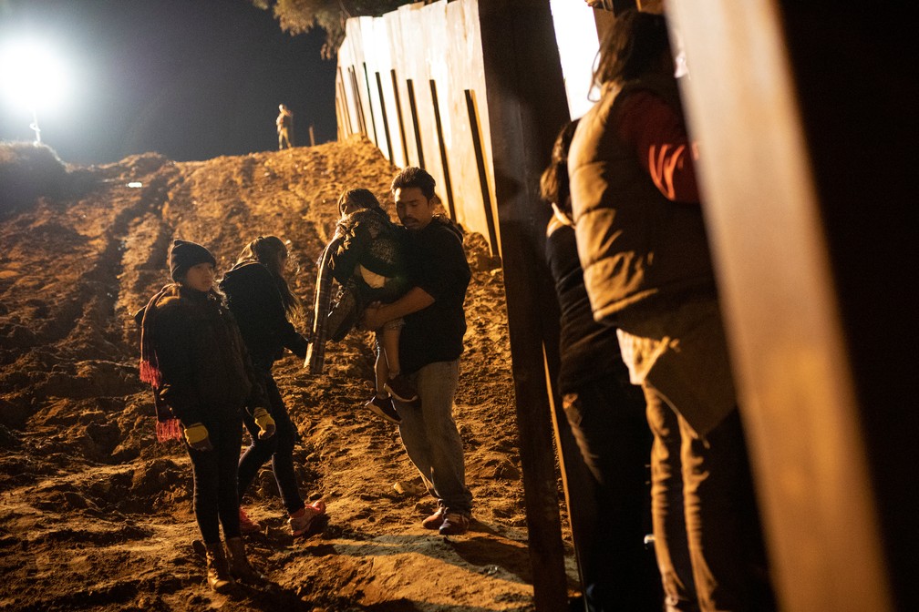 Migrants parte da caravana da AmÃ©rica Central tentam passar para os Estados Unidos na noite desta segunda-feira (3) â Foto: Alkis Konstantinidis/Reuters