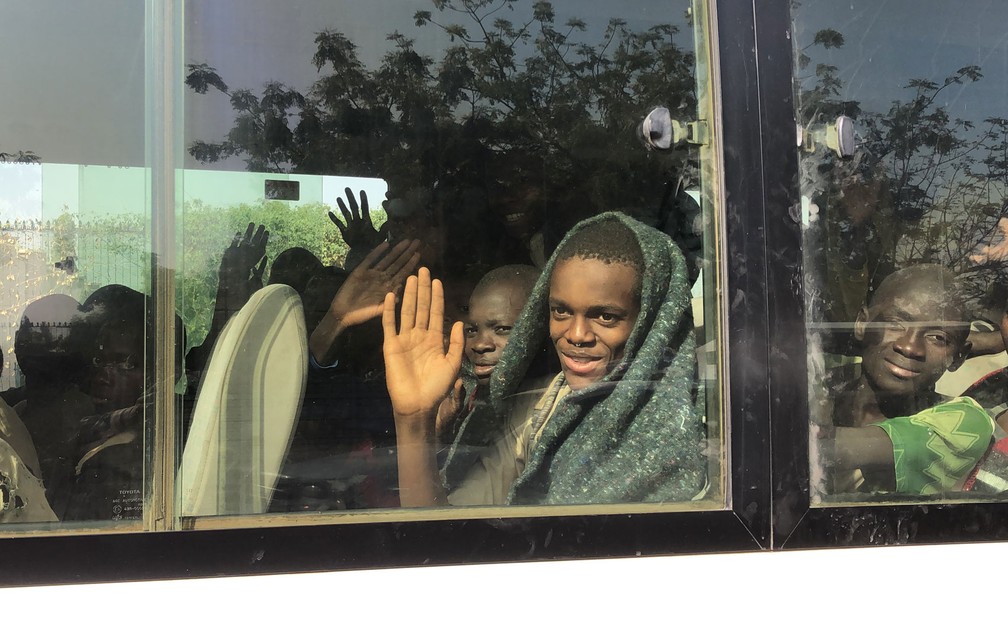 Meninos que haviam sido sequestrados pelo Boko Haram são vistos através da janela de ônibus ao serem levados até a sede do governo do estado de Katsina, na Nigéria, após terem sido libertados, na sexta-feira (18) — Foto: Kola Sulaimon/AFP 