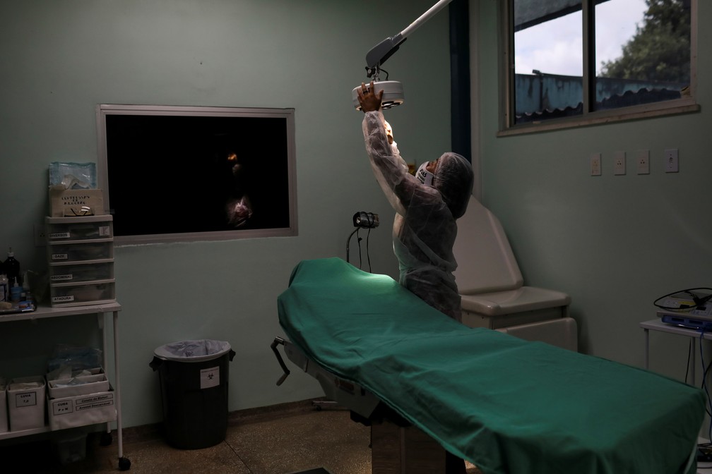 Vanda ajusta a luz em uma sala de exames na Fundação Alfredo da Mata de Dermatologia Tropical e Venereologia, onde trabalha — Foto: Bruno Kelly/Reuters