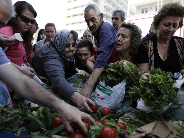 Pessoas se acotovelam para pegar alimentos (Foto: Reuters/John Kolesidis )