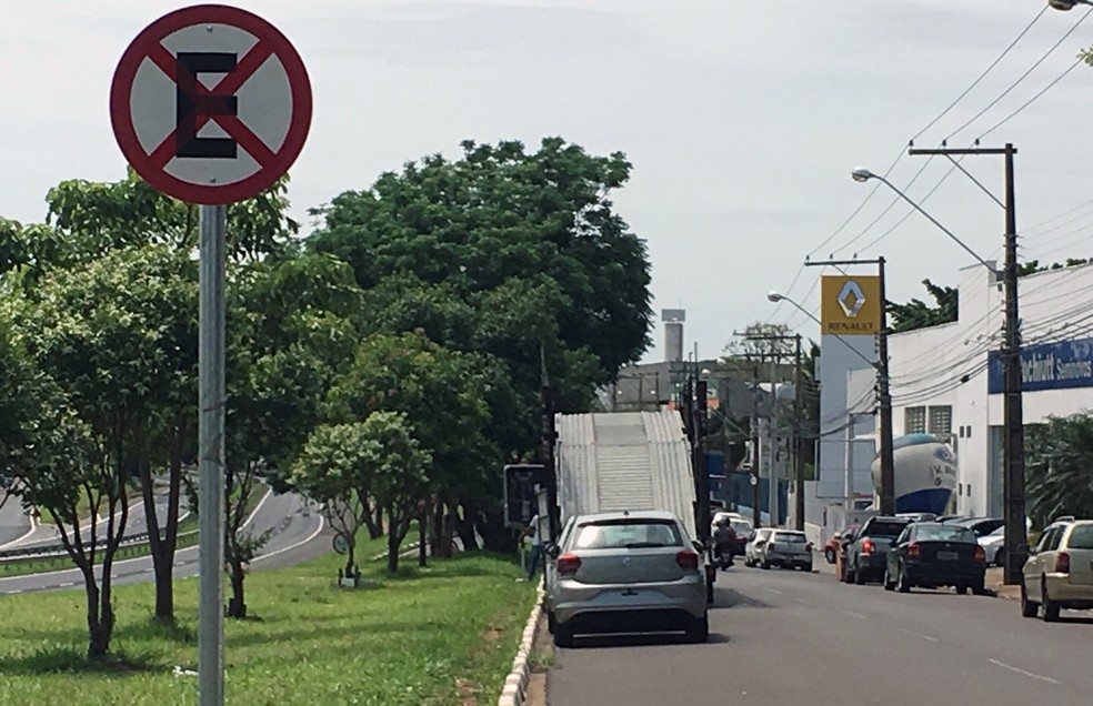 Caminhão estacionado irregularmente descarrega diversos carros na Avenida Joaquim Constantino, em Presidente Prudente (Foto: Valmir Custódio/G1)