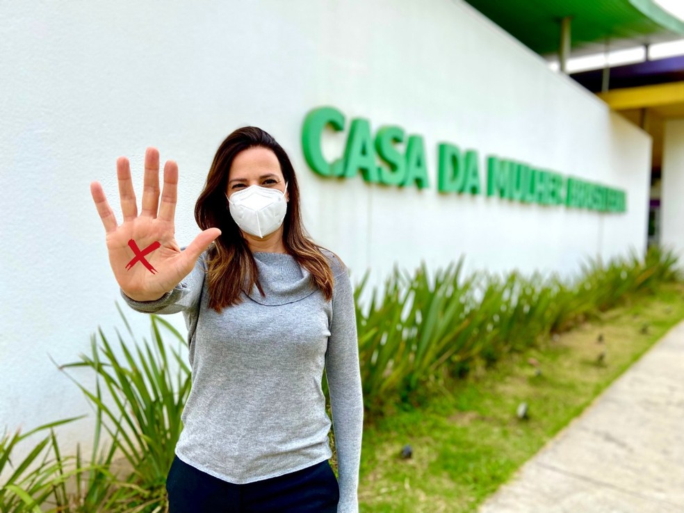 Secretária Municipal de Direitos Humanos e Cidadania, Claudia Carletto, mostra um 'X' na mão para lembrar da campanha que pede para mulheres vítimas de violência usarem a letra com sinal de que estão em perigo — Foto: Everton Clarindo / SMDHC