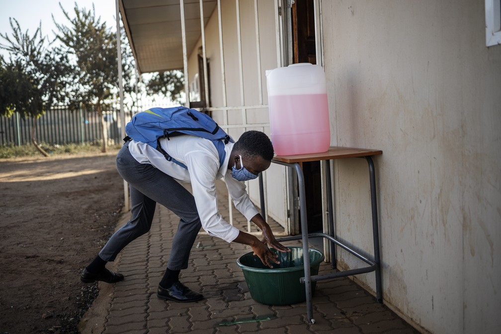 Aluno lava as mãos em escola na África do Sul nesta segunda-feira (8) — Foto: Michele Spatari/AFP