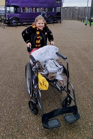 Emily apoiada em sua cadeira de rodas (Foto: Reprodução/Mirror)