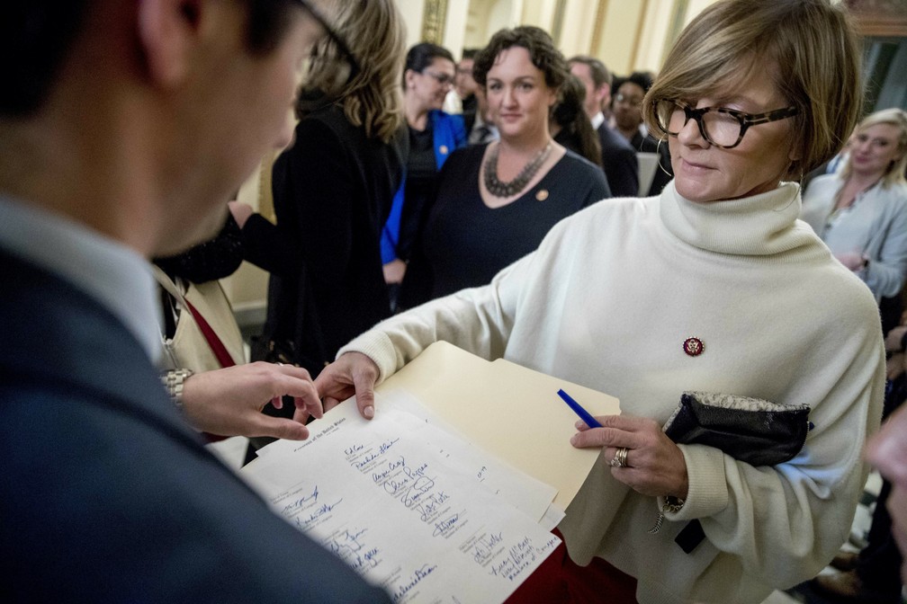 Deputada democrata Susie Lee pede assinaturas para carta que pede o fim da paralisação do governo para ser entregue ao senador republicano Mitch McConnell — Foto: Andrew Harnik/AP Photo