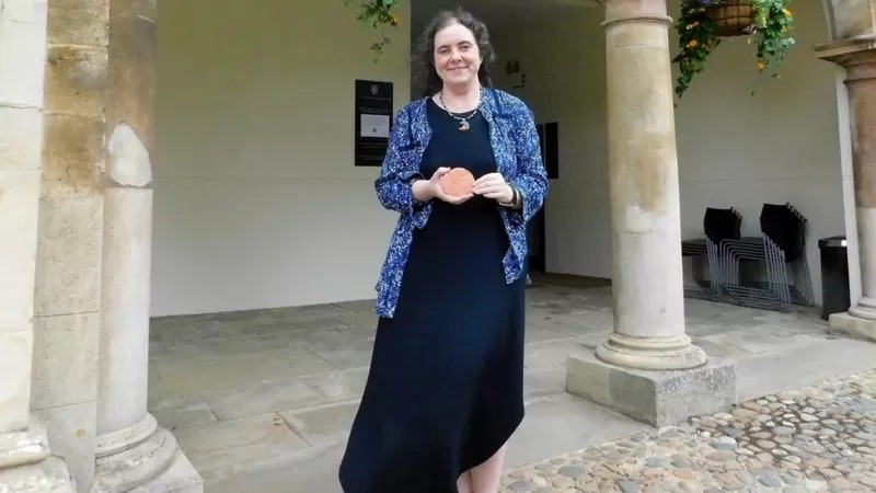 Philippa Steele, especialista em escritos antigos da Universidade de Cambridge, no Reino Unido, com a tábua de argila que contém uma mensagem para o futuro (Foto: ARQUIVO PESSOAL via BBC)