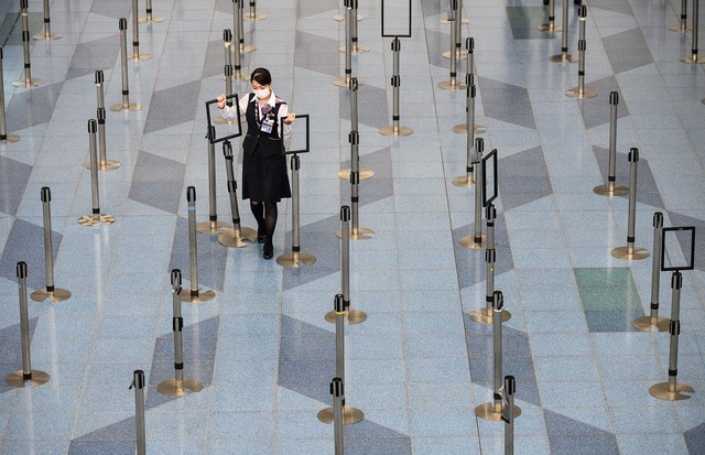 TOPSHOT - A facemask-clad airline employee works at the departure hall of Tokyo's Haneda Airport on March 10, 2020. - The death toll from the COVID-19 illness caused by the novel coronavirus neared 4,000, with more than 110,000 cases recorded in over 100  (Foto: AFP via Getty Images)
