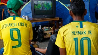 Sem-tetos assistem ao jogo da seleção brasileira contra a Suíça nas ruas de São Paulo — Foto: MIGUEL SCHINCARIOL/AFP
