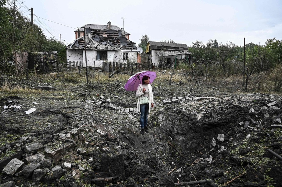 Mulher observa destroços em frente à casa destruída, em Kramatorsk, região de Donetsk, Ucrânia
