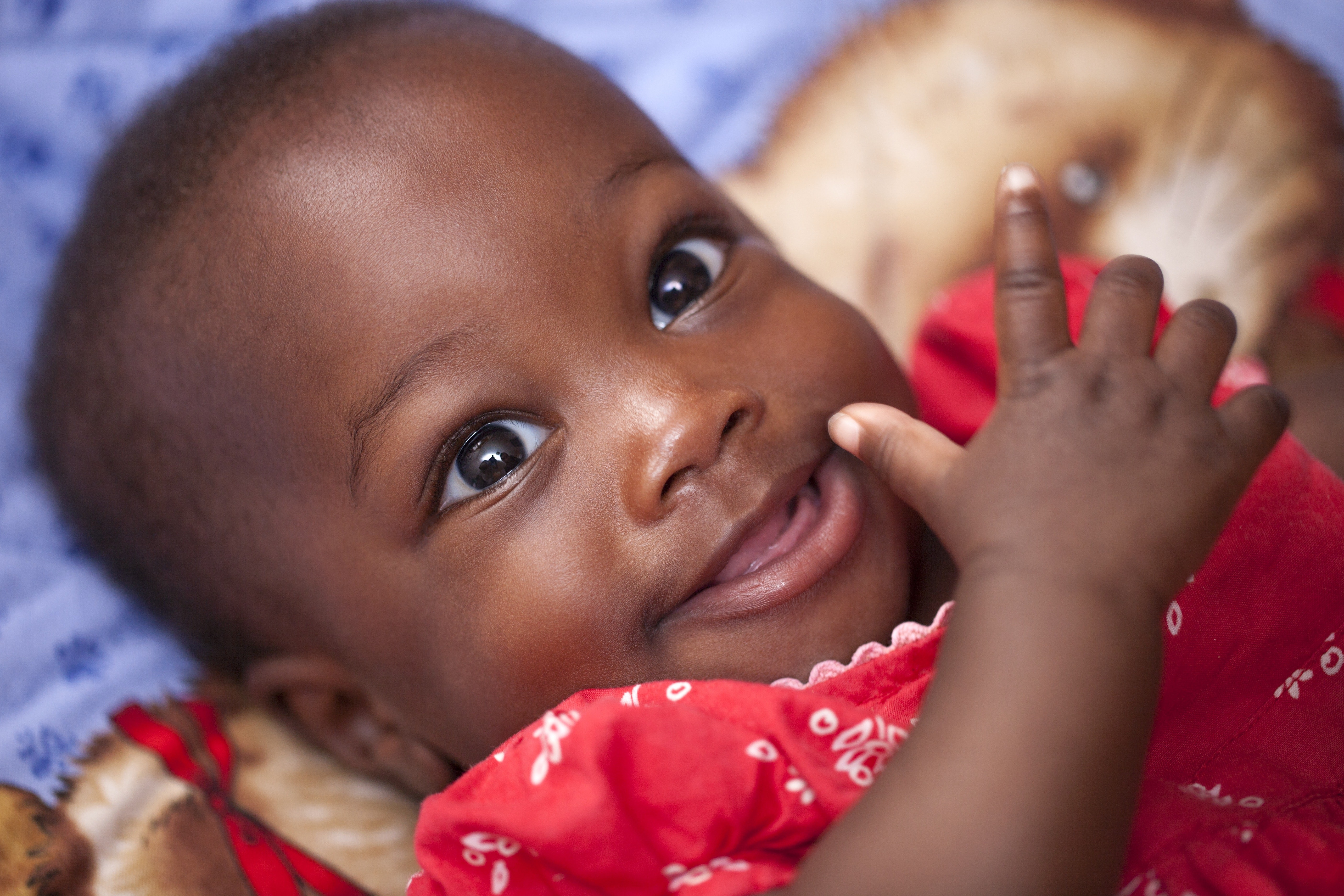 Bebê sorrindo usando vestido vermelho (Foto: Pixabay)