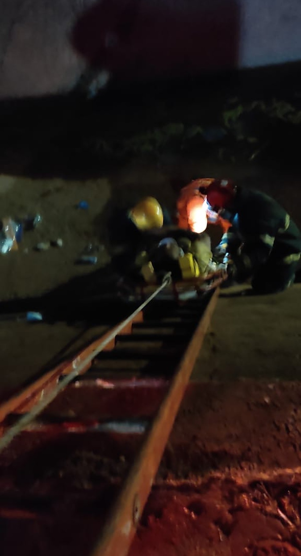 Vítima foi colocada em uma maca que foi arrastada através de uma escada — Foto: Corpo de Bombeiros/ Divulgação