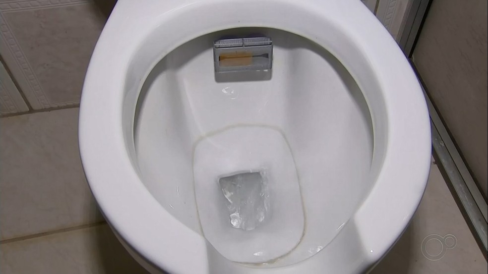 Aparelho é colocado na saída de água do vaso sanitário — Foto: Reprodução/TV TEM
