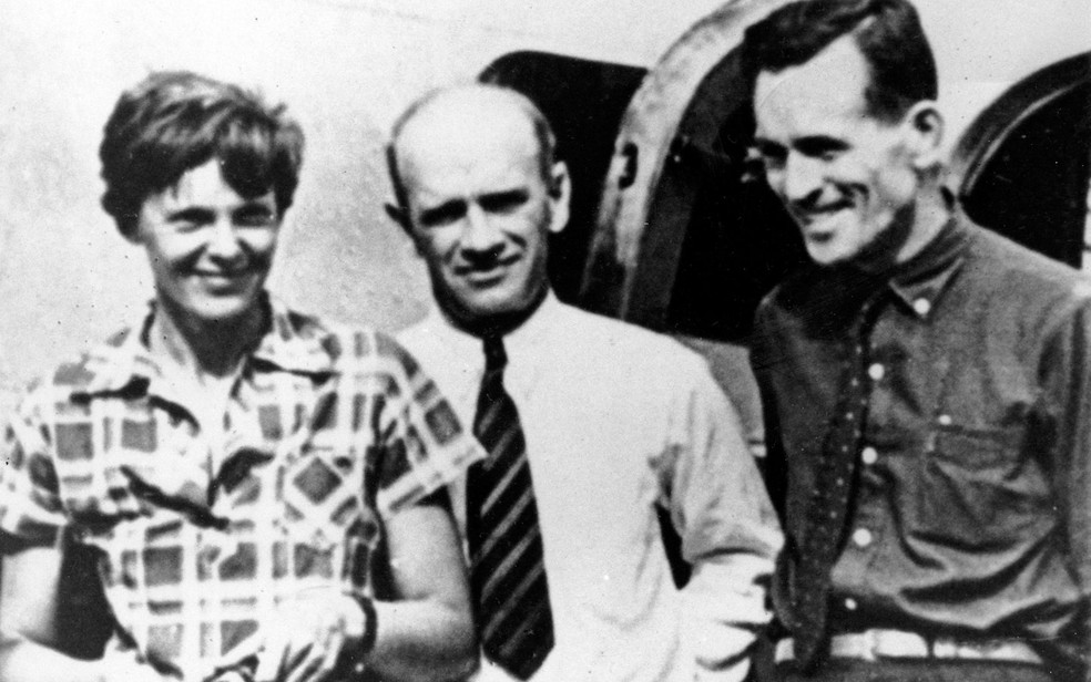 Foto de 2 de julho de 1937 mostra Amelia Earhart e seu navegador Fred Noonan (direita) posando ao lado do minerador F.C. Jacobs em Lae, na Nova Guiné, momentos antes de a aviadora decolar da ilha Howland e desaparecer (Foto: AP Photo, File)