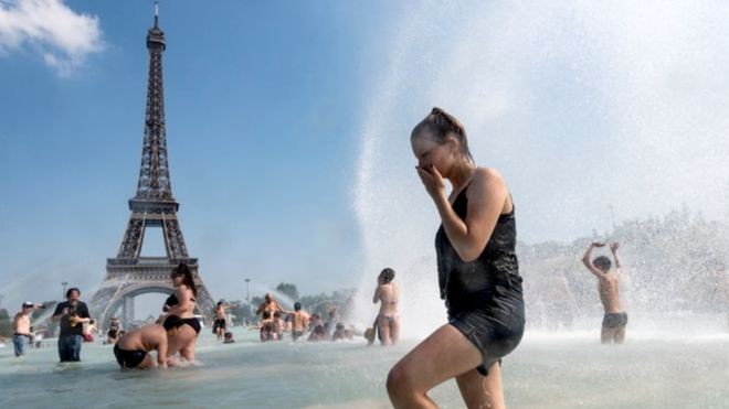 Mulher se refresca em meio a onda de calor em Paris, França (Foto: Getty Images via BBC)