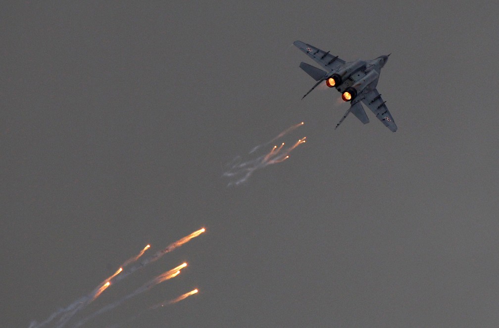 Uma aeronave MiG-29 da Força Aérea Polonesa dispara sinalizadores durante uma apresentação em 24 de agosto de 2013 — Foto: REUTERS/Kacper Pempel