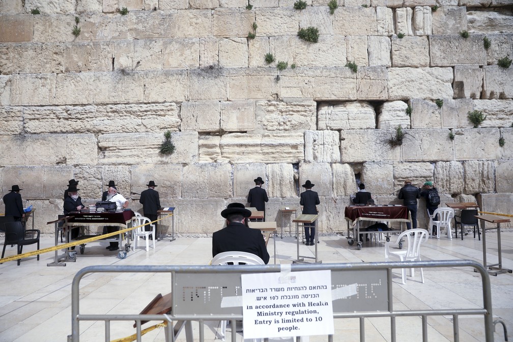 Judeus rezam separadamente no Muro das Lamentações neste domingo (15) após medida que proíbe aglomeração com mais de 10 pessoas em Israel — Foto: Mahmoud Illean/AP Photo