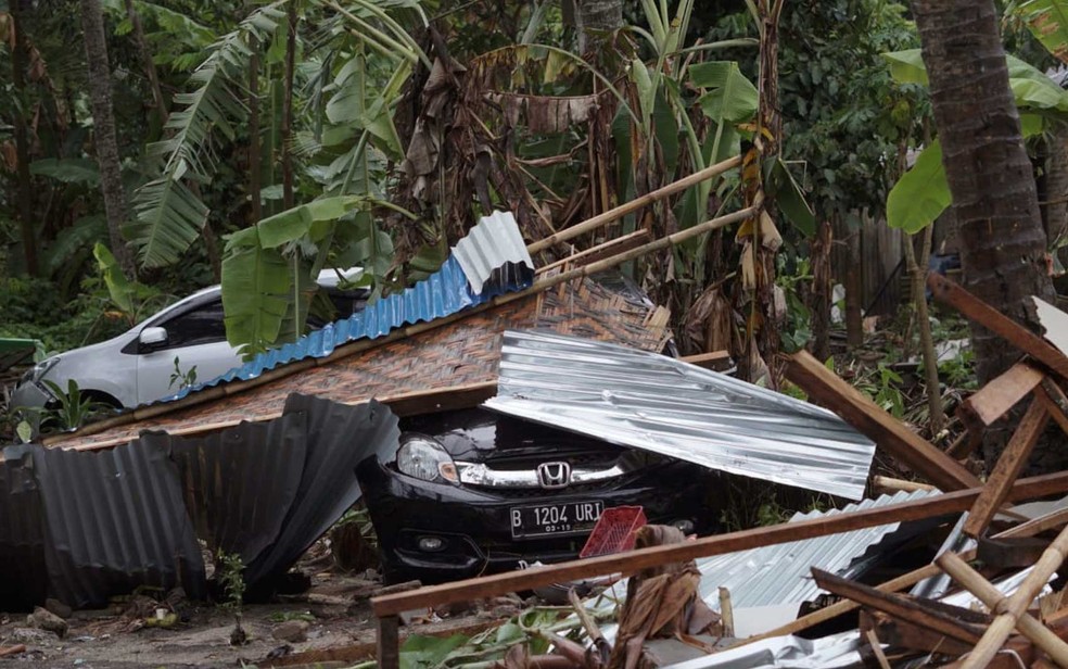 Carro coberto por destroços em área devastada na Indonésia — Foto: Dian Triyuli Handoko/ AP Photo