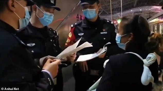 Compradora do bebê sendo interrogada por policiais em Hefei, leste da China, após agir de forma suspeita em um trem (Foto: Reprodução/Daily Mail)