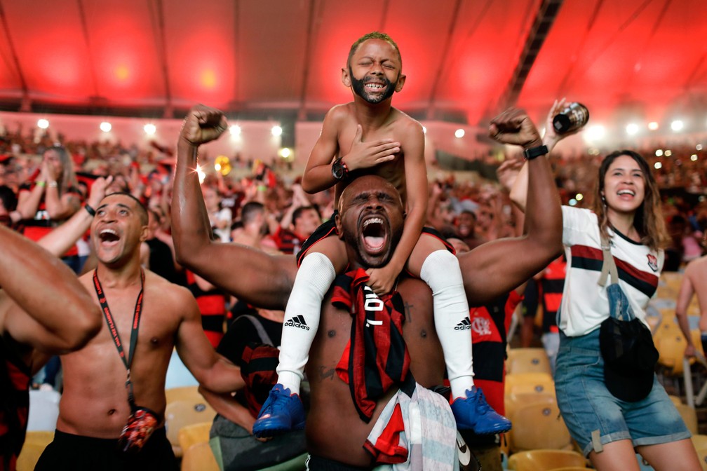 23 de novembro - Torcedores do Flamengo comemoram o gol marcado por Gabigol contra o River Plate na final da Copa Libertadores durante transmissão em uma tela gigante instalada no estádio do Maracanã, no Rio de Janeiro. O Flamengo venceu o time argentino por 2x1 e foi campeão da campetição sul-americana — Foto: Silvia Izquierdo/AP