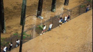Pedestres são obrigados a usar as grades do Jardim Botânico, em 1996 para escapar da água que cobriu a rua com nome do bairro — Foto: Márcia Foletto/Agência O Globo