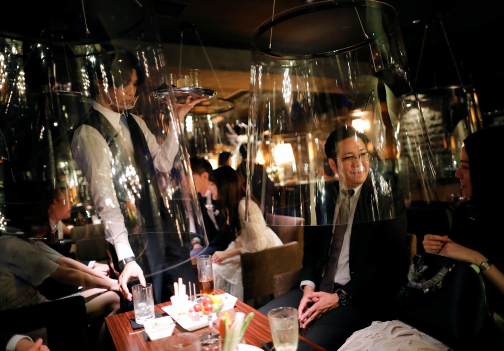 Telas acrílicas em formato de aquário são vistas instaladas como parte de novas medidas de distanciamento social e prevenção da infecção contra a Covid-19 no Jazz Lounge Encounter em Tóquio, no Japão — Foto: Issei Kato/Reuters