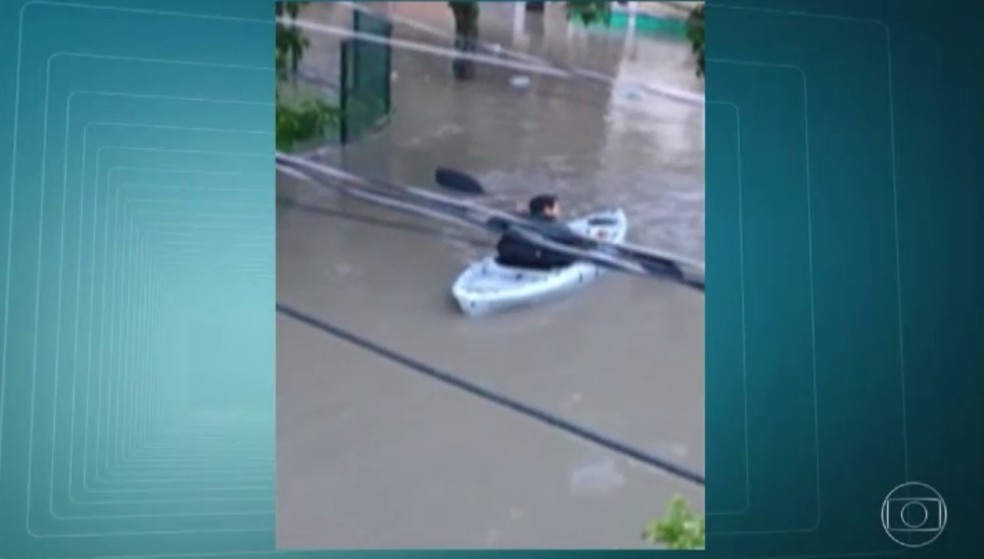 Alagamento chega a 1m e homem usa bote para sair de casa no Rio (Foto: Reproduo/TV Globo)