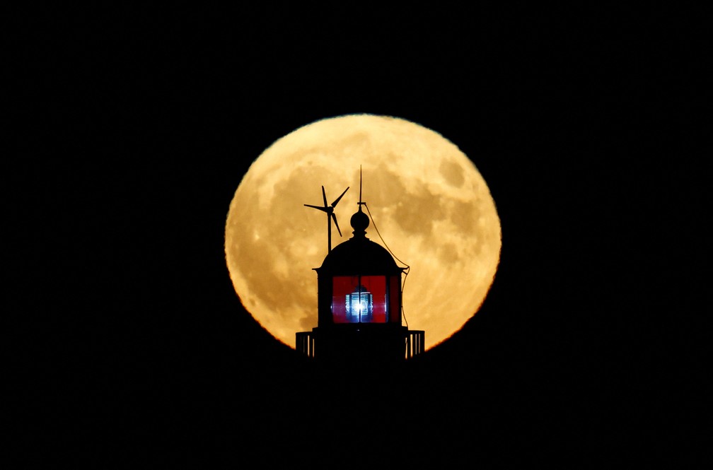 Superlua atrás de um farol, na França — Foto: Reuters