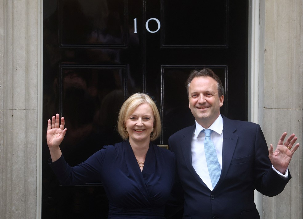 Primeira-ministra britânica Liz Truss e seu marido Hugh O'Leary acenam para jornalistas em frente ao gabinete do governo em Downing Street, em Londres — Foto: REUTERS/Hannah McKay