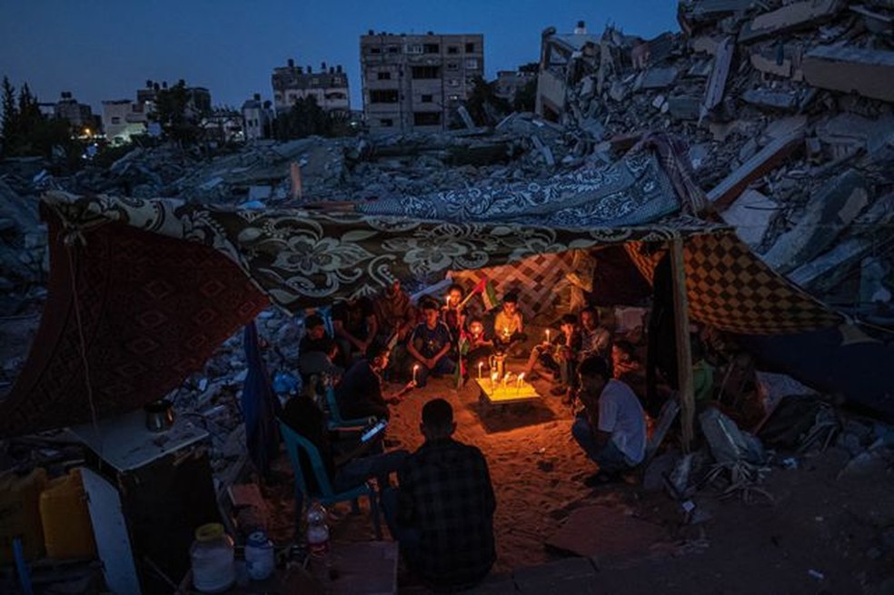 Crianças palestinas se reúnem com velas durante um frágil cessar-fogo em Beit Lahia, Gaza, em 25 de maio de 2021, após um protesto de crianças no bairro contra ataques a Gaza — Foto: Fatima Shbair para Getty Images