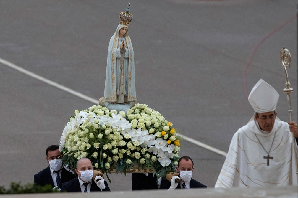 Imagem de Nossa Senhora de Fátima é carregada no santuário católico de Fátima, em Portugal, praticamente vazio, nesta quarta-feira (13)  — Foto: Armando Franca/AP