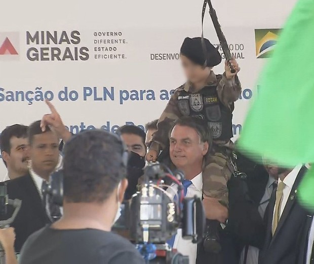 Bolsonaro com criança fardada sobre os ombros (Foto: Reprodução TV Globo)