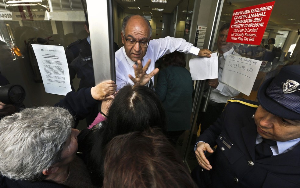 Gerente de um banco tenta acalmar correntistas esperando a reabertura de agÃªncia no Chipre. (Foto: Yannis Behrakis/Reuters /Arquivo)
