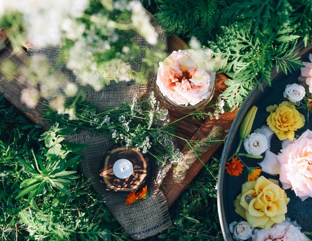 Multicolored flowers floating in the water surrounded by nature. Bath with natural plants. Rustic lifestyle. (Foto: Getty Images)