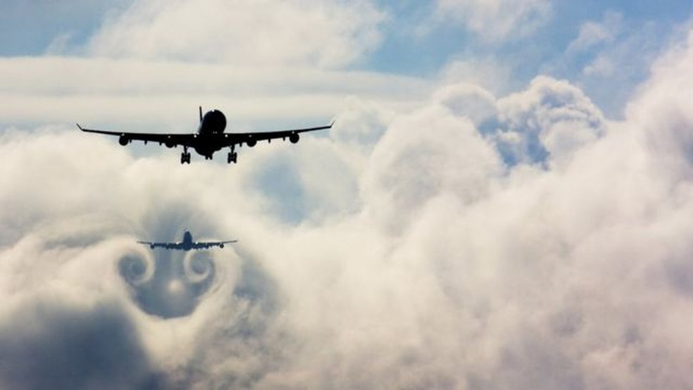 Os aviões normalmente seguem uns aos outros para pousar em uma linha no momento - aqui, um avião voa através da turbulência causada pelo que está na frente — Foto: Getty Images/BBC