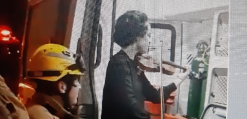 Motorista toca violino para bombeiros do DF após ser socorrida em acidente de carro — Foto: TV Globo/ Reprodução